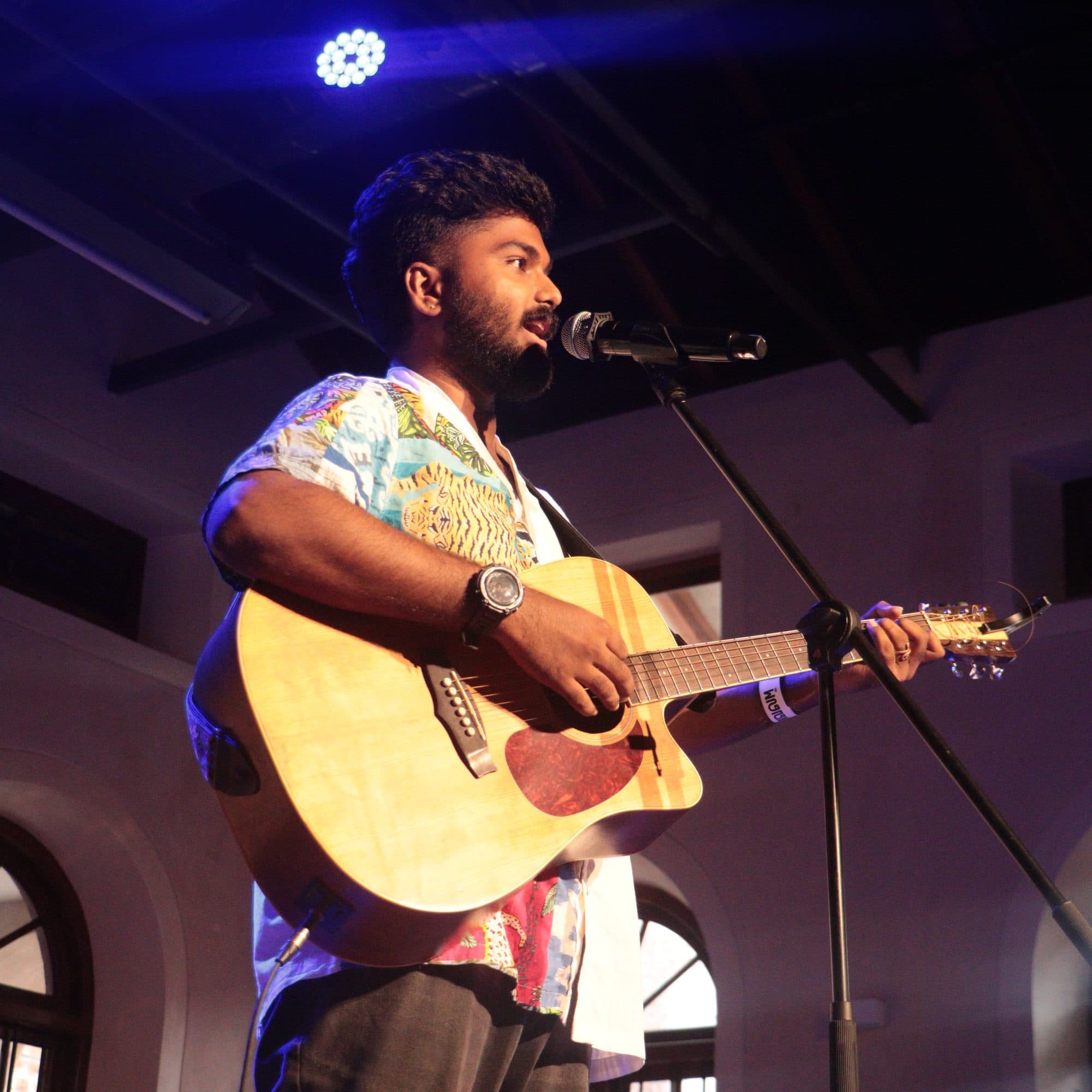 Ajay Nathan tuning his guitar on stage